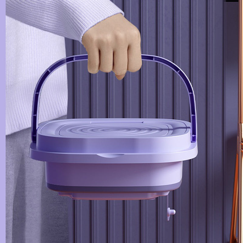 Person holding a purple plastic container with a handle against a neutral background